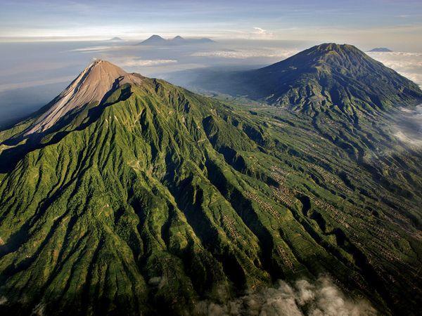 Mount Merapi, Indonesia Green vegetation surrounds villages on the slopes of Mount Merapi, a highly active volcano in Central Java, Indonesia. Thousands of people, lured by fertile volcanic soils, live on or near Merapi. Many lives have been lost to the volcano’s frequent eruptions, which are accompanied by high-speed pyroclastic flows and mudflows called lahars.[John Stanmeyer/CNTV]