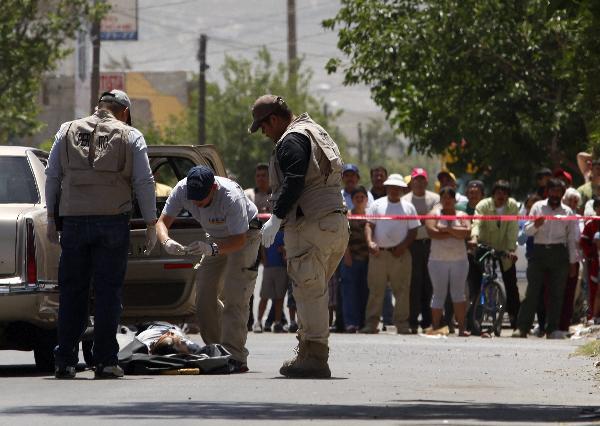 Policemen investigate the body of a victim shot by an unknown armed men in in the northern Mexican city of Ciudad Juarez, April 28, 2010. Eight people, including two teenagers, were killed when a group of armed men stormed a bar in the northern Mexican city of Ciudad Juarez Tuesday night, the authorities said on April 29, 2010.[Xinhua] 