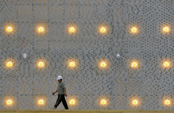 A worker walks past a wall made of recycled plastic bottles at the Flora Expo construction site in Taipei, taiwan on April 13, 2010. The world&apos;s first green building made of plastic bottles will be used as one of the 14 exhibition halls at the 2010 Taipei International Flora Expo, starting from November 6. 