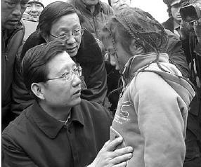 Qiang Wei, Party secretary of Qinghai, comforts a little girl in the Yushu quake area on April 20. 