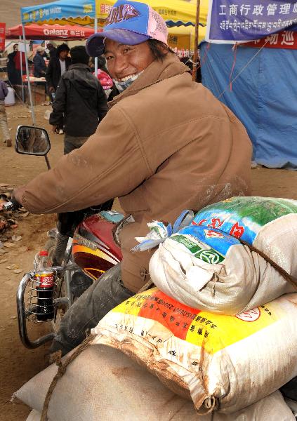 A Tibetan man recieves rice in Gyegu Town in quake-hit Yushu County, northwest China's Qinghai Province, April 28, 2010. Relief supplies were handed out to quake victims in Yushu. 