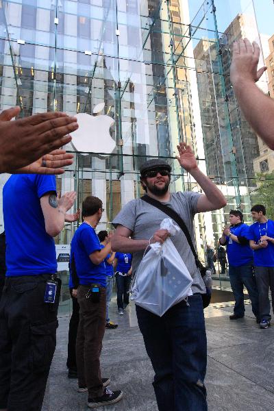 A man waves hands after buying an iPad 3G outside of an Apple Store at the 5th Avenue in New York, the United States, April 30, 2010. The iPad 3G was formally on sale to public in U.S. on Friday with the price of 130 US dollars higher than iPad Wi-Fi. [Wu Kaixiang/Xinhua]