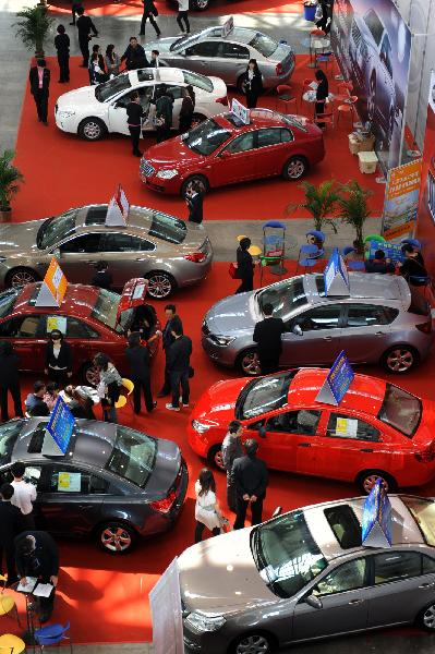 Visitors watch cars on display during the first day of an auto show in Nanjing, central China&apos;s Jiangsu Province, May 1, 2010. [Han Yuqing/Xinhua]