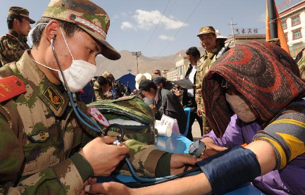 Members of the Xining detachment of the armed police force offer free diagnostic services in quake-hit Yushu County, northwest China&apos;s Qinghai Province, May 1, 2010. [Tao Ming/Xinhua]