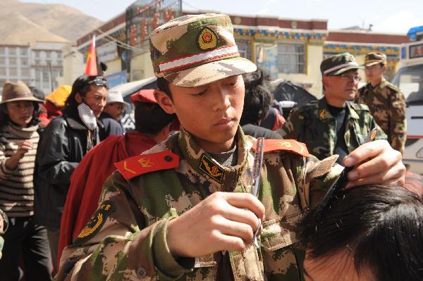 Members of the Xining detachment of the armed police force offer free haircut services in quake-hit Yushu County, northwest China&apos;s Qinghai Province, May 1, 2010.[Tao Ming/Xinhua]