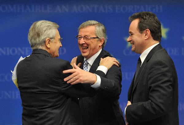 President of Eurogroup and Prime Minister of Luxembourg Jean-Claude Juncker (C) hugs President of European Central Bank Jean-Claude Trichet (L) as Greek Finance Minister George Papaconstantinou looks on at a press conference after Eurogroup finance ministers meeting in Brussels, capital of Belgium on May 2, 2010. 