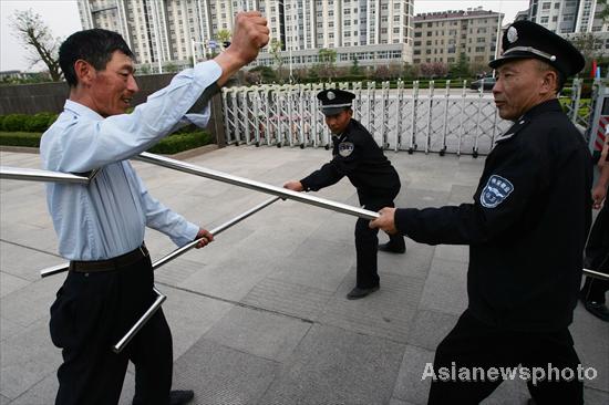 Security guards contain an attacker with specially designed forks in a mocked attack in Dongming Middle School in Weifang, East China's Shandong province May 2, 2010. In wake of a string of violent incidents against students, Chinese authorities are strengthening security checks and implementing measures to prevent assaults at schools and kindergartens. [Asianewsphoto]