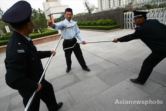 Security guards contain an attacker with specially designed forks in a mocked attack in Dongming Middle School in Weifang, East China's Shandong province May 2, 2010. 