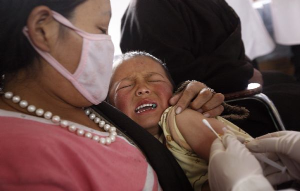 A child is vaccinated in Jiegu Town of northwest China's quake-hit Yushu Prefecture, on May 3, 2010. Over 2,500 children aged 0 to 12 have been vaccinated against measles, parotitis, rubella and hepatitis B so far in Yushu. A total of 6,000 to 7,000 children will be vaccinated.(Xinhua/Shen Bohan)