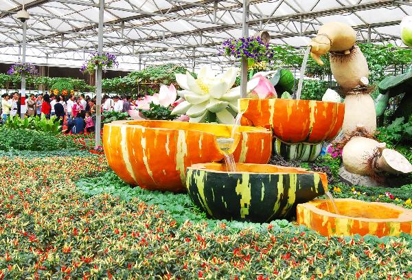 Visitors walk around to appreciate varieties of unique sculptings of pumpkins and other vegetable forms, at the Vegetable Fair, which attracts great many visitors and procurators for sightseeing and deal-order by the virtue of new and high-tech cultivation methods, affluent varieties of strains, as well as novel horticultural sculpting, during the May 1 vacation, in Shouguang, east China's Shandong Province, May 2, 2010. The fair is slated to last until May 20. [Xinhua/Dong Naide]