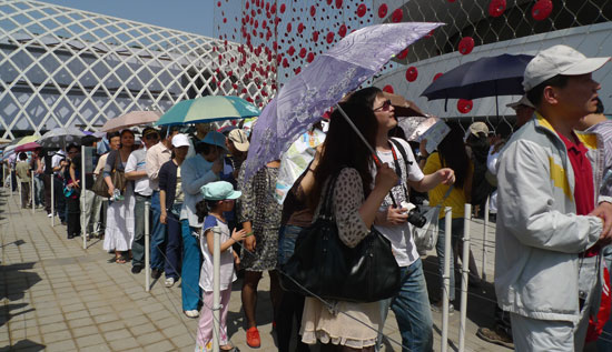 People are queuing outside Swiss Pavilion on May 3, 2010. The outdoor temperature has reached 30°C, but thousands of visitors are still waiting to enter Swiss Pavilion. [China.org.cn / Xu Lin]