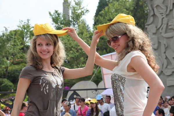 A pair of foreign twin sisters pose for photos during the Sixth Mojiang International Twins Festival. The festival attracts nearly one thousand pairs of twins in Mojiang county, Yunnan province, May 2, 2010. Mojiang county, which is on the Tropic of Cancer and is called the place where the Sun turns, holds the record that there are more than 1,200 pairs of twins among about 300,000 local people.