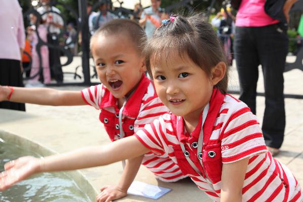 A pair of Chinese twins enjoy their happy time during the Sixth Mojiang International Twins Festival which attracts nearly one thousand pairs of twins in Mojiang county, Yunnan province, May 2, 2010. 