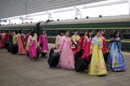 Actresses and actors of the Democratic People's Republic of Korea song and dance troupe transfer trains to Beijing in Dandong city, Liaoning province, May 2, 2010. 