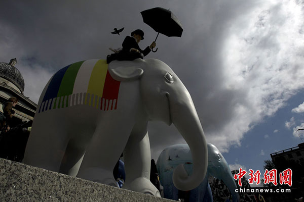 An elephant artwork designed by Jack Vettriano stands in Trafalgar Square in London, May 4, 2010. The London Elephant Parade 2010 will see the capital taken over by 260 life-size baby elephants, all hand-painted by an assortment of established and emerging talent from the art and design world. [chinanews.com.cn]