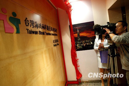 A journalist takes photos in the first Taiwan tourism office which was opened on the mainland in Beijing on May 4, 2010. [Photo: CNSphoto]