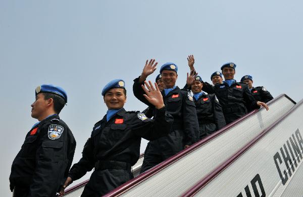 Members of the eighth contingent of Chinese riot police in Haiti walk down the ladder of the plane upon their arrival in Beijing, capital of China, May 4, 2010.