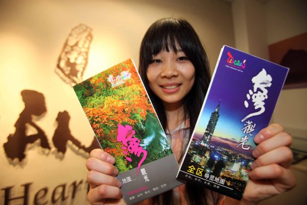 A lady shows the tourism introduction pamphlets of China's Taiwan Province at the Beijing Office of the Taiwan Strait Tourism Association in Beijing, China, May 4, 2010. 