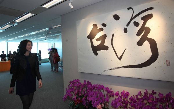 A staff worker walk past a calligraphy work writing 'Taiwan' at the front desk at the Beijing Office of the Taiwan Strait Tourism Association in Beijing, China, May 4, 2010. 