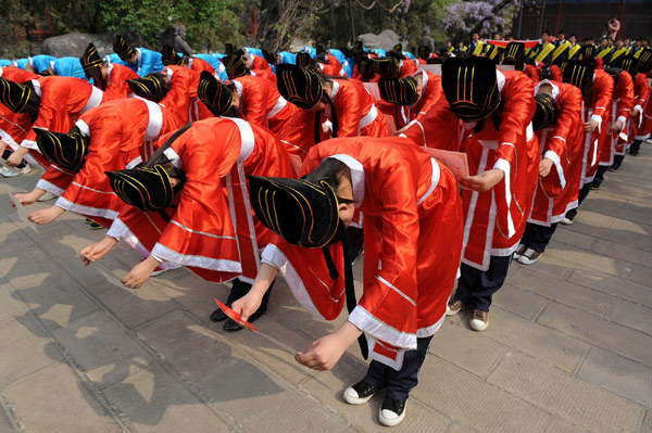 Students bow to their parents and guests at the ceremony. 