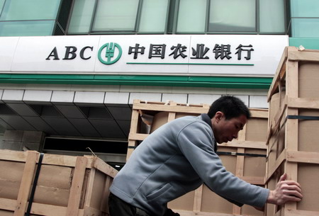 A worker unloads boxes outside an Agricultural Bank of China branch in Shanghai.