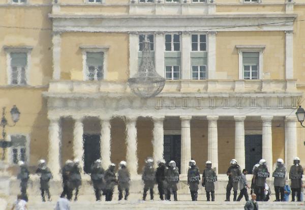 Greek riot police safeguard the parliament building in downtown Athens, capital of Greece, May 5, 2010. Three people died in a fire that broke out at a bank and some 40 others injured on Wednesday during a massive protest against austerity measures which turned out to be a violence in downtown Athens. [Phasma/Xinhua]