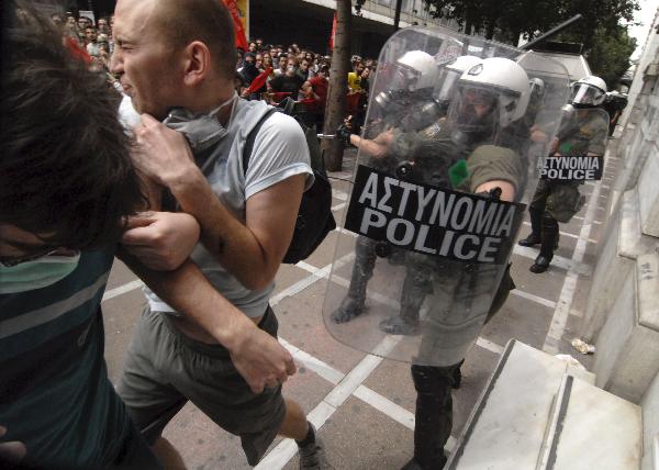 Greek anarchists are chased by police during a protest in downtown Athens, capital of Greece, May 5, 2010. Three people died in a fire that broke out at a bank and some 40 others injured on Wednesday during a massive protest against austerity measures which turned out to be a violence in downtown Athens. [Phasma/Xinhua]