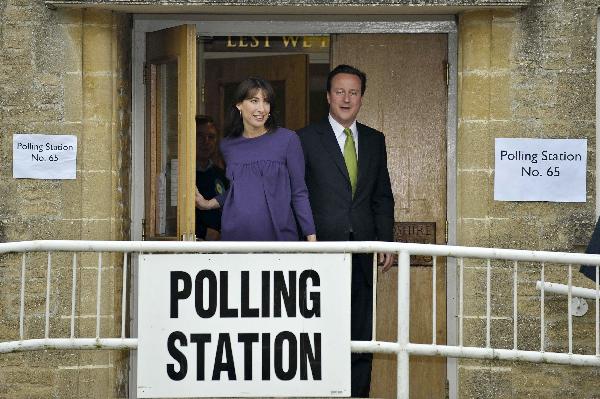 Britain's Conservative Party leader David Cameron (R) leaves with his wife Samantha after voting in Oxfordshire, England, May 6, 2010. British voters went to the polls on Thursday morning as up to 50,000 polling stations across the country opened in the most tightly contested general election in decades. (Xinhua/PA Wire/Ben Birchall)