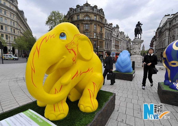 Tourists walk among the elephant sculptures in London May 6, 2010. A herd of life-sized &apos;baby elephants&apos; hand-painted by artists and designers were dotted around London to raise awareness of the plight of Asian elephants. [Xinhua]