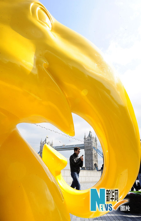 A tourist walks among the elephant sculptures in London May 6, 2010. A herd of life-sized &apos;baby elephants&apos; hand-painted by artists and designers were dotted around London to raise awareness of the plight of Asian elephants. [Xinhua]