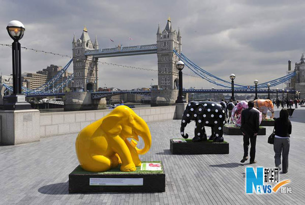 Tourists walk among the elephant sculptures in London May 6, 2010. [Xinhua]