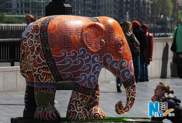 Tourists walk among the elephant sculptures in London May 6, 2010. [Xinhua]