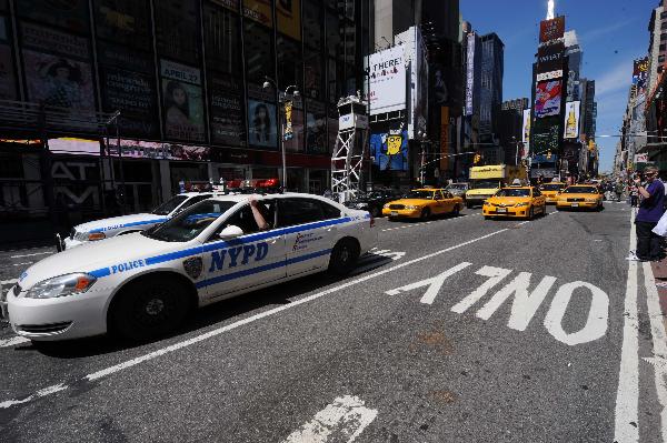 Police give all-clear to pedestrians and traffic on Times Square as the suspicious package was proved not a threat in New York, the United States, May 7, 2010. The New York Police Department said the suspicious package that forced evacuation at the heart of Times Square at lunchtime was examined by the Bomb Squad and determined to be just a lunch cooler and safe.