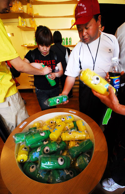 People buy water bottles in the theme of football in Brazil Pavilion at the 2010 World Expo in Shanghai, east China, on May 7, 2010. The decoration design of South Africa Pavilion and Brazil Pavilion at the 2010 World Expo are both in the theme of football as they will respectively host the 2010 World Cup of South Africa and 2014 World Cup of Brazil.