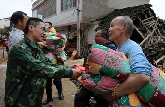 Villagers receive relief materials in Tianxin Village, Egong Town of Dingnan County in east China's Jiangxi Province, May 7, 2010. Seven people were dead and five were missing after floods and landslides wreaked havoc in Jiangxi over the past two days. [Xinhua photo]