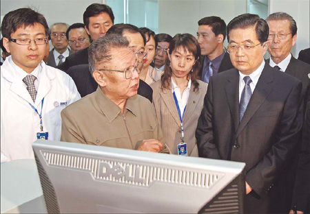 DPRK leader Kim Jong-il (front left), accompanied by President Hu Jintao (second right), visits a bio-tech company in Beijing on Thursday.