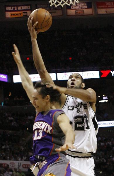 San Antonio Spurs forward Tim Duncan (R) holds off Phoenix Suns guard Steve Nash as he goes in for a shot in the first half of Game 4 of their NBA Western Conference semi-final playoff series in San Antonio, Texas May 9, 2010. (Xinhua/Reuters Photo)