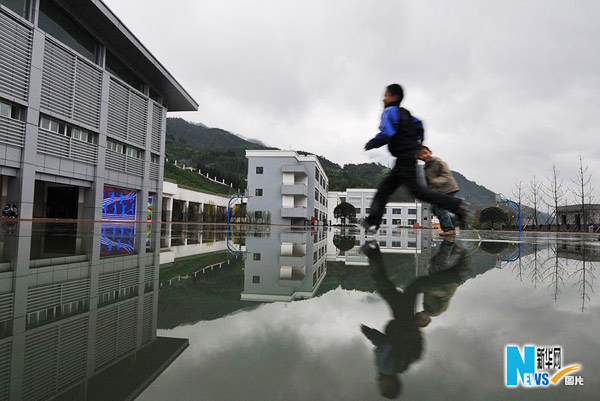 Two elementary school pupils walk in Bayi Shuimo Primary School, on April 12, 2010. [Photo: Xinhua]