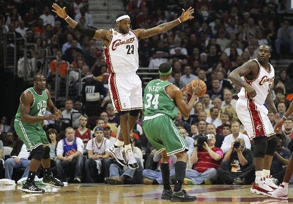 Cleveland Cavaliers' LeBron James (23) jumps while defending Boston Celtics' Paul Pierce (34) as Celtics Kendrick Perkins (L) and Cavaliers' Shaquille O'Neal follow the play during the first quarter in Game 5 of their NBA Eastern Conference playoff basketball series in Cleveland, May 11, 2010. 