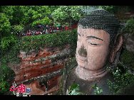 China's largest Buddhist statue, the seated Maitreya Buddha, is 71 m in height, with shoulders 28 m wide. His smallest toenail is large enough to accommodate a seated person. As the locals say, 'the mountain is a Buddha and the Buddha is a mountain'. [Photo by Wang Maohuan]
