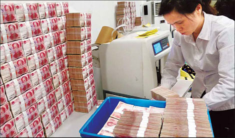 An employee counting banknotes at a China Merchants Bank branch in Nanjing. China's broad money supply (M2) increased 21.48 percent year-on-year to about 65.66 trillion yuan by the end of April.