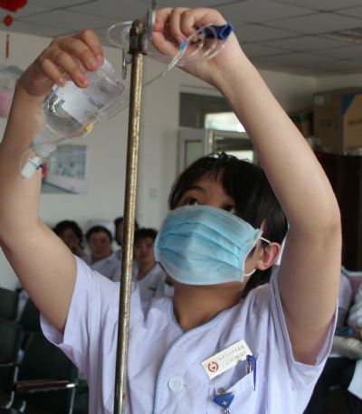 A nurse shows the professional skills in an activity of marking the International Nurses Day, which falls on May 12, in Tianjin, north China, May 11, 2010.