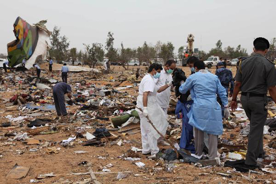 Rescue workers examine the debris of Afriqiyah airline flight 8U771 at Tripoli airport May 12, 2010. [Xinhua photo]