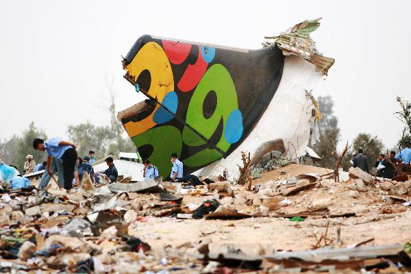 Rescue workers examine the debris of the crashed plane at the spot in Libyan capital of Tripoli, May 12, 2010.