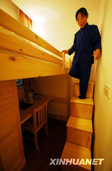 A staff member cleans a single room in a newly built mini hotel located in the center of Shanghai city, April 13, 2009. Taking up only about 7 square meters, the room comes complete with all necessary facilities, including a private bathroom. Each such room costs around 100 RMB (14.6 USD) per night. [File Photo: Xinhuanet]