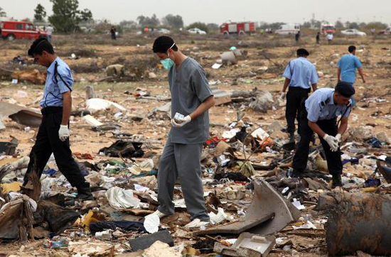 Rescue workers examine the debris of Afriqiyah airline flight 8U771 at Tripoli airport May 12, 2010. [Xinhua photo]