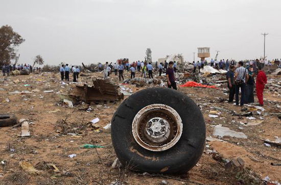 Rescue workers examine the debris of Afriqiyah airline flight 8U771 at Tripoli airport May 12, 2010. [Xinhua photo]