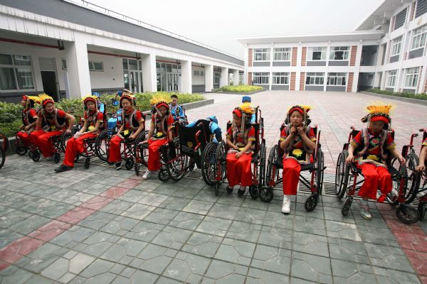 Handicapped students dressed in costumes of Qiang ethnic group wait to rehearse their dance in You'ai School of Dujiangyan, Sichuan Province, May 11, 2010.