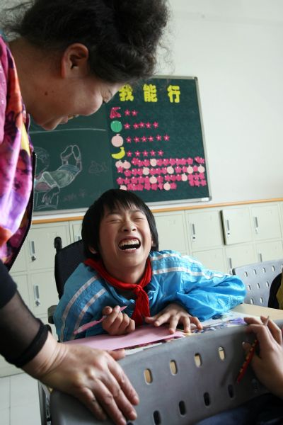 Handicapped student Zhou Jieyu smiles in an art class in You'ai School of Dujiangyan, Sichuan Province, on May 10, 2010.