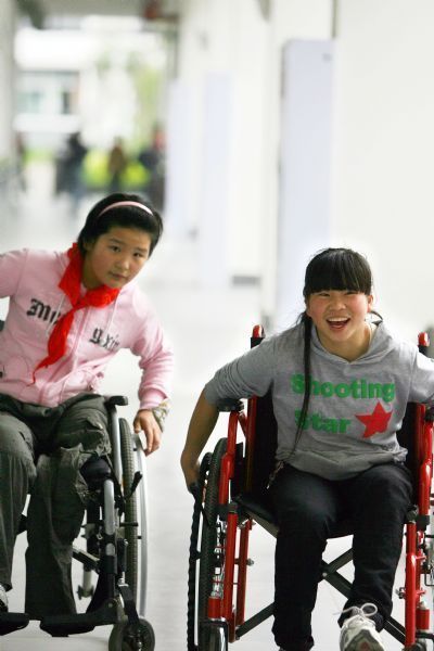 Gao Xiaoqin (R)and Zhang Chunmei from Xiaojin County play in You'ai School of Dujiangyan, Sichuan Province, on May 7, 2010. 